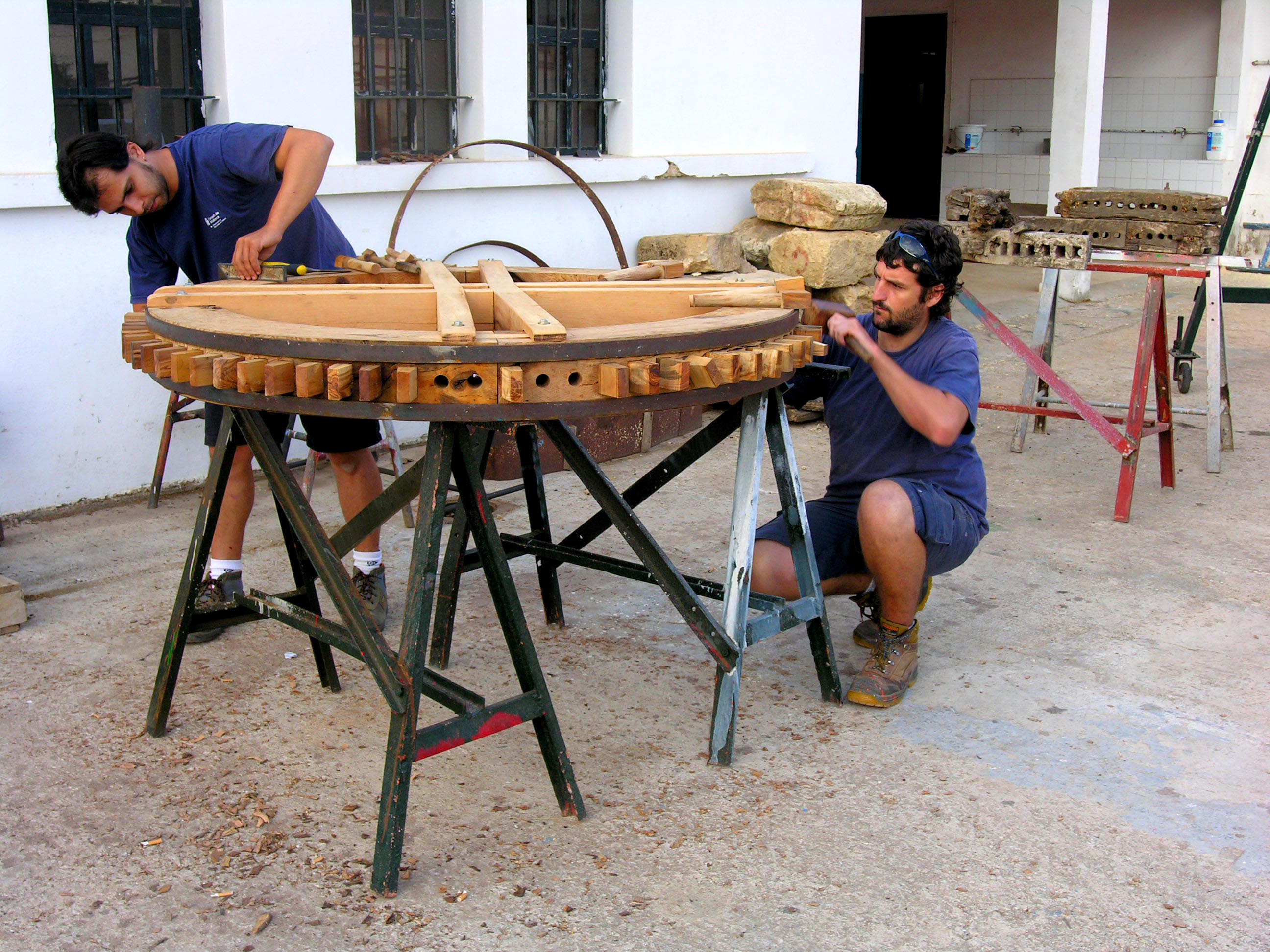 Treballadors del taller posen a punt la roda del molí de sang de Son Servera.